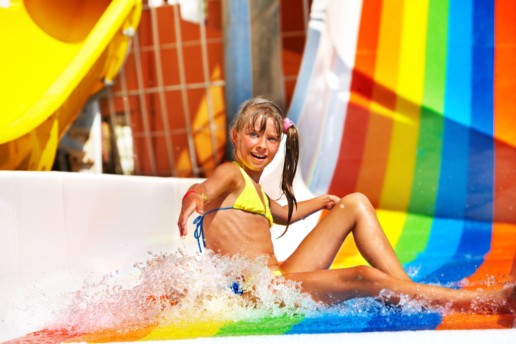 Child in bikini sliding water park.