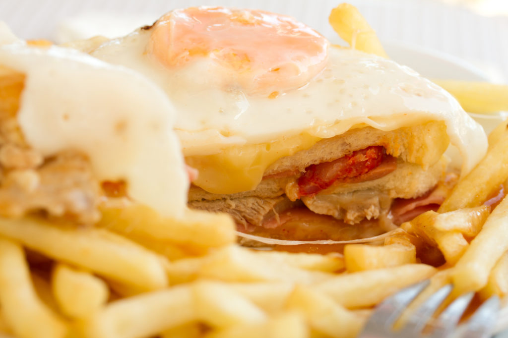 typical portuguese dish francesinha on white plate