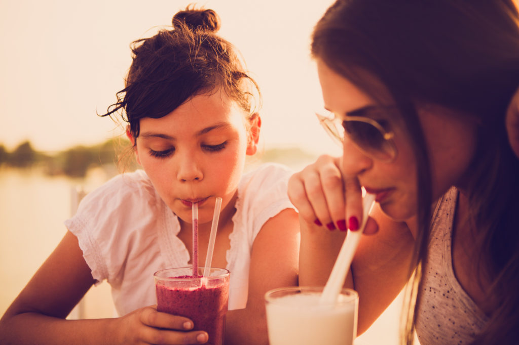 Mother and daughter drinking juice at cafe