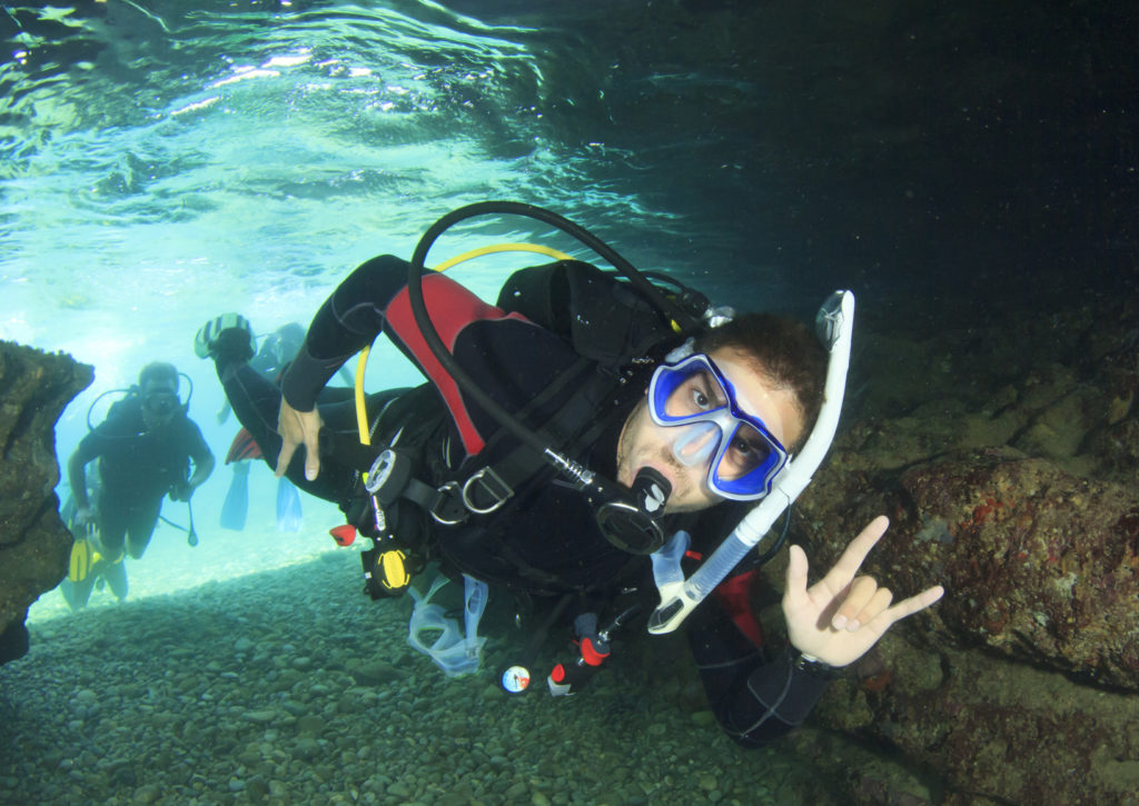 Scuba diver enters underwater cave