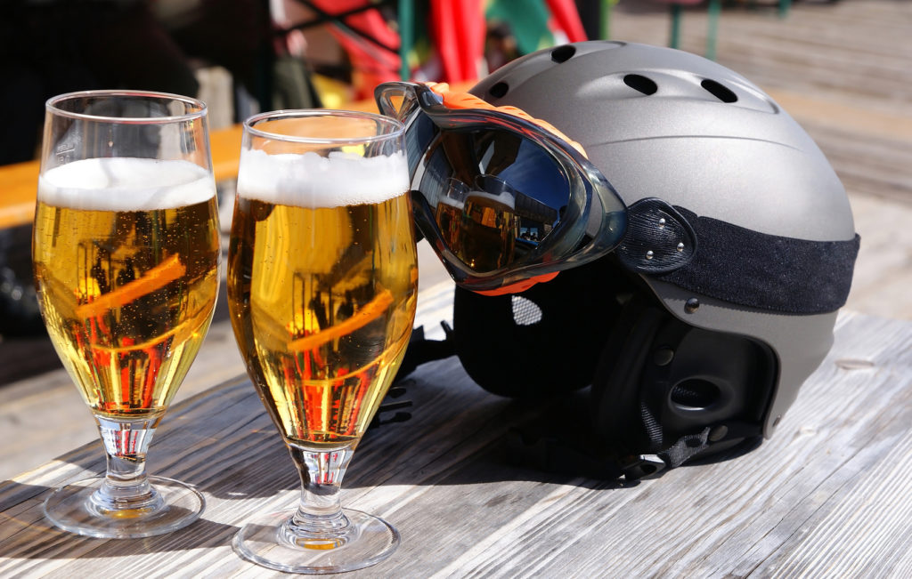 Two glasses of beer and a ski helmet on the table