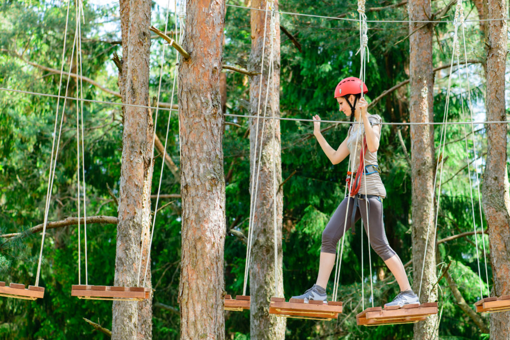adventure climbing high wire park - Young woman on course in mountain helmet and safety equipment