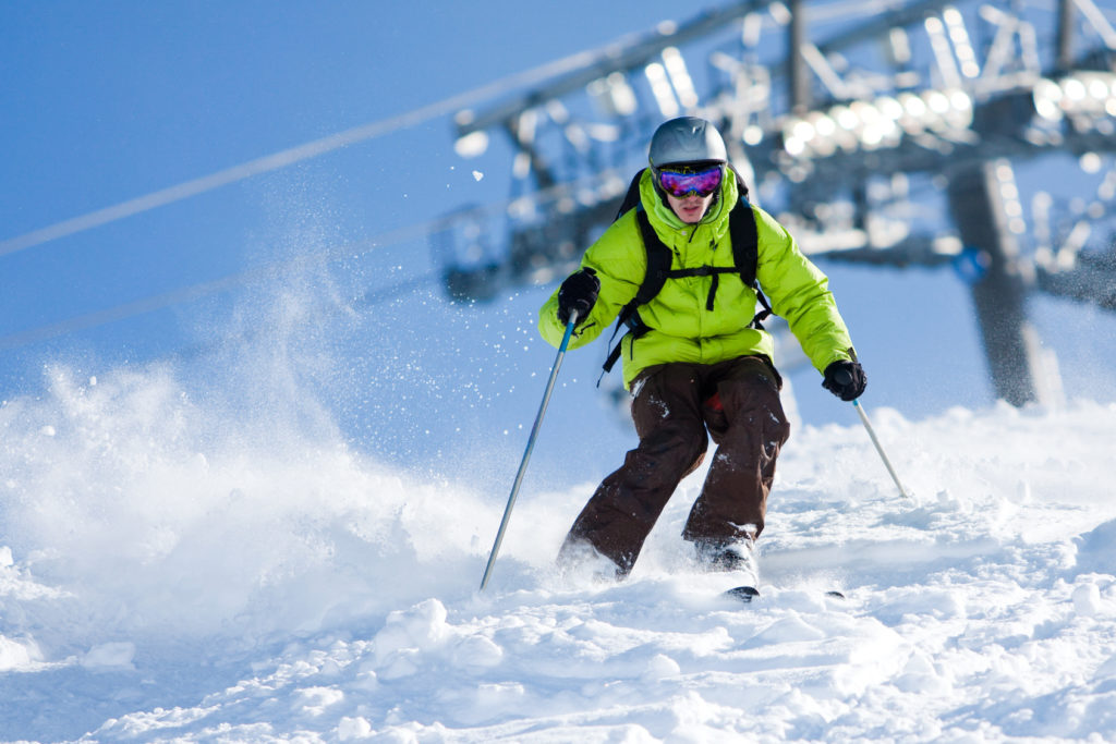 Young man on skis out of slopes. Off-piste skiing