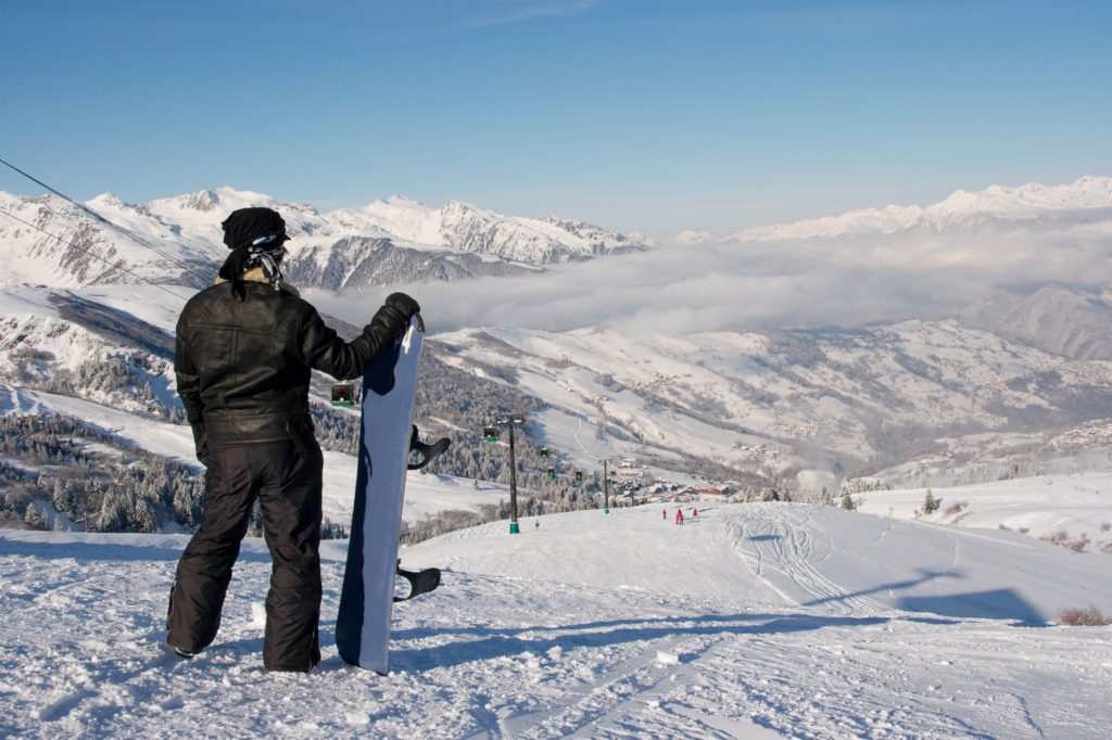 Snowboarder standing at the top of the slope