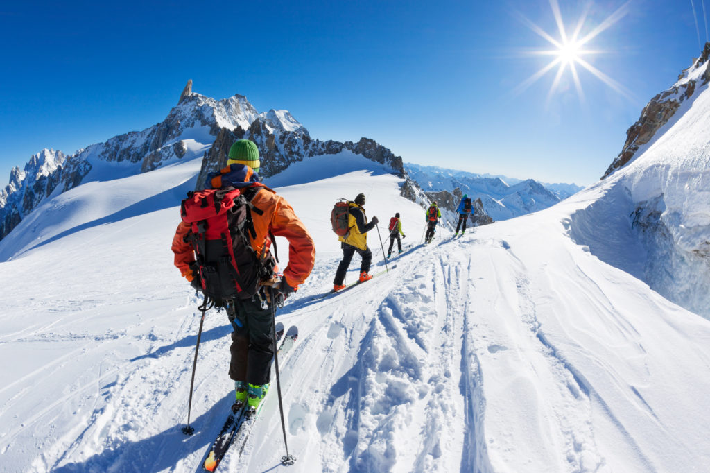 A group of skiers start the descent of Vallée Blanche, the most famous offpist run in the Alps: 25 Km long, Vallée Blanche descent links Italy and France through the ‘mer de Glace’ glacier in the Mont Blanc Massif. Chamonix, France, Europe.