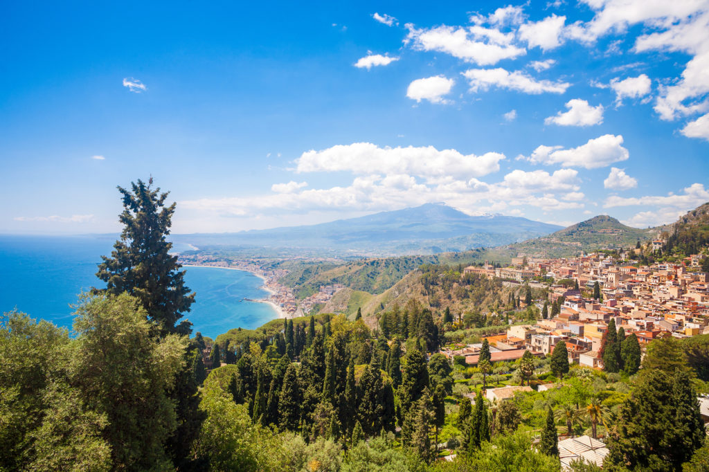 Taormina's Giardini-Naxos bay with the sea and the Etna and Catania in the back in Sicily, italy.
