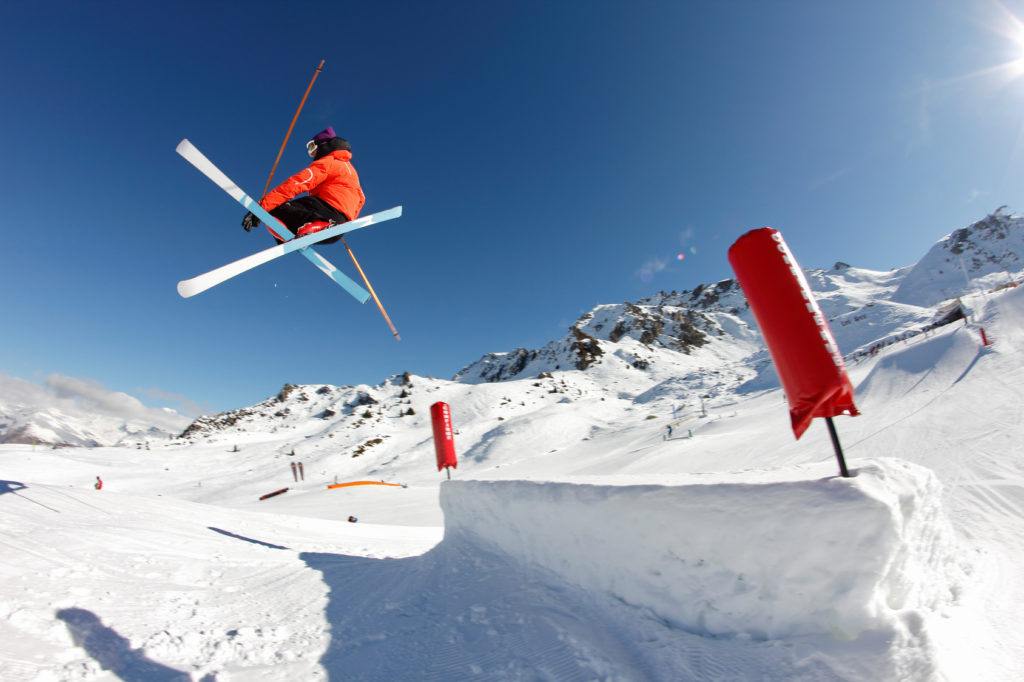 skieur freestyle réalise une figure sur une table d'un snowpark, freestyle, figure phil grab - ski croisées