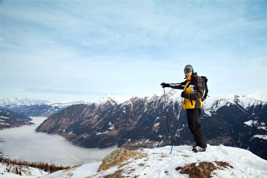 The man points on mist over valley, Austrian Alps