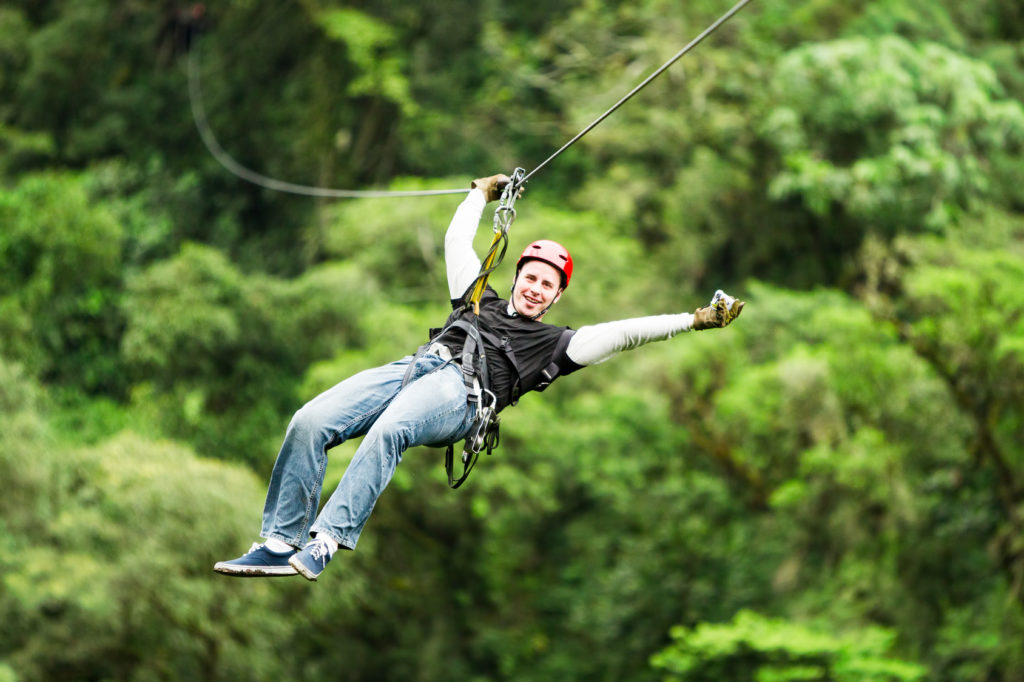 Adult Male Tourist Wearing Casual Clothing On Zip Line Or Canopy Experience In Ecuadorian Rain Forest