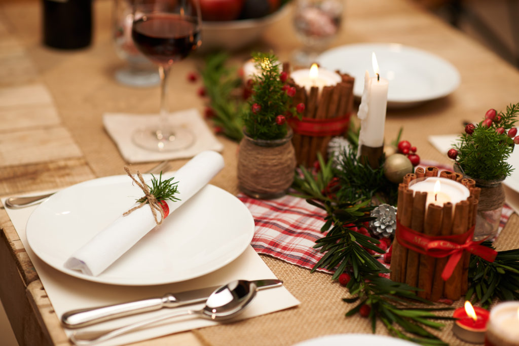 Decoration of Christmas table: candles, juniper branches and napkins