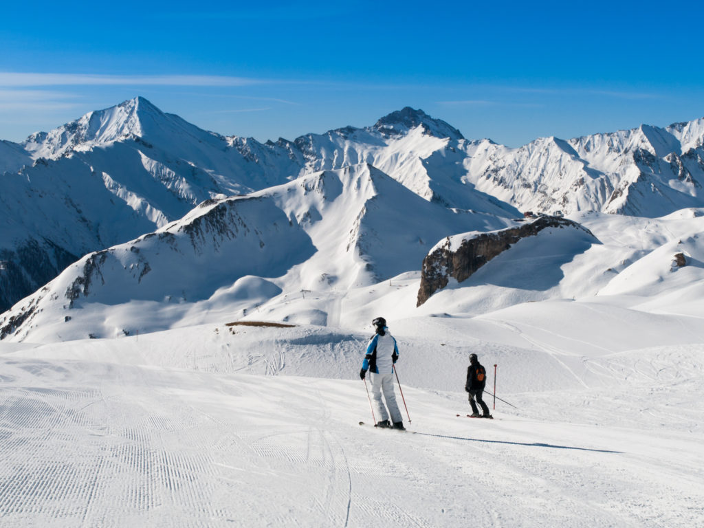 Sunny winter day in alpine ski resort with blue sky and bright white snow, Ischgl and Samnaun, Silvretta Arena, Austria - Switzerland